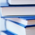 Vertical shot of piled blue hardcover books in close-up detail.